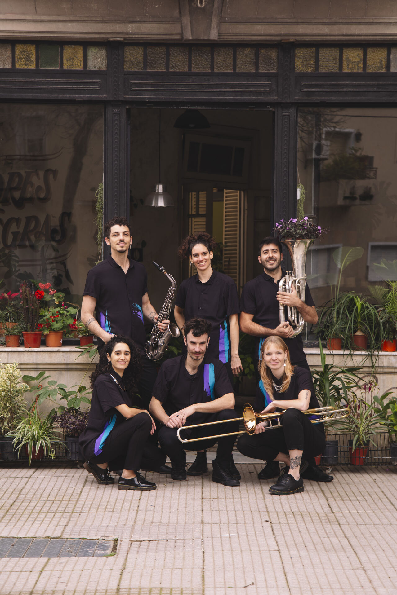 Desmadre Orkesta posando en la vereda con sus instrumentos